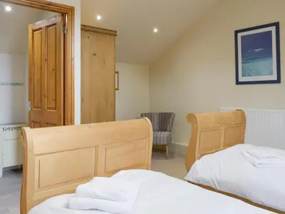 a bedroom with two beds and a chair at The Old Dairy - Ukc3413 in Bolton by Bowland
