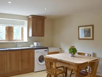 a kitchen with a table and a washing machine at The Old Dairy - Ukc3413 in Bolton by Bowland