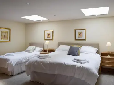 two beds in a room with white walls and skylights at The Old Dairy - Ukc3413 in Bolton by Bowland