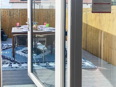a glass door of a patio with a table with chairs at Jasmin's Retreat in Cleveleys