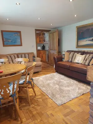 a living room with a couch and a table at The Coach House Holiday Cottage, Southport in Southport