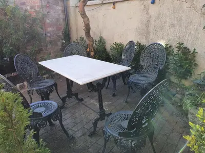 a white table and chairs in a garden at The Coach House Holiday Cottage, Southport in Southport