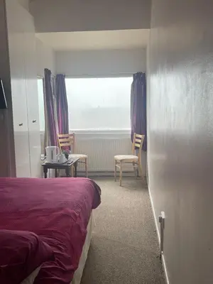 a bedroom with a bed and a table and chairs at Sea Princess Hotel Blackpool in Blackpool
