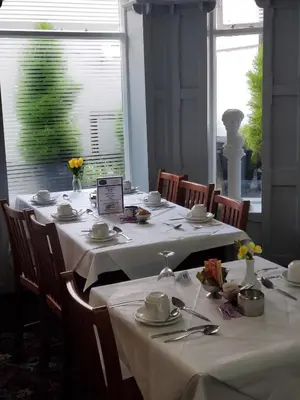 a dining room with tables with white tablecloths and chairs at The Melville Hotel - Central Location in Blackpool