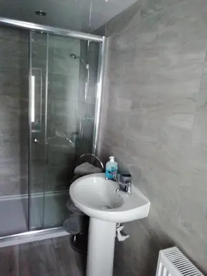 a bathroom with a sink and a shower at Brown Cow Cottage in Dalton in Furness