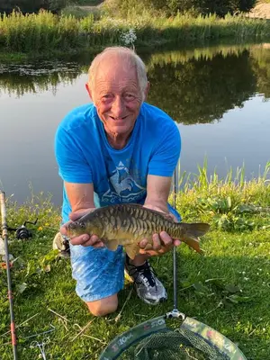 a man holding a fish in his hands at Carmels Caravan Borwick Lakes in Carnforth