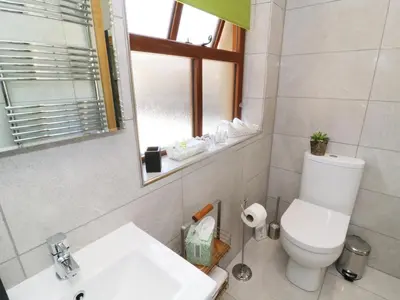 a bathroom with a toilet and a sink and a mirror at Sunnybrook Cottage in Clitheroe