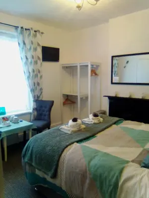 a hotel room with a bed and a chair and a tv at The braeside families and couples in Blackpool