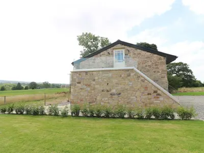 a stone house with a window on top of it at Deer Lodge in Blackburn