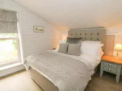 a bedroom with a bed and a window at Deer Lodge in Blackburn