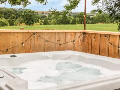a jacuzzi tub with a wooden fence at Deer Lodge in Blackburn