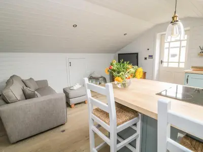 a kitchen and living room with a table and a couch at Deer Lodge in Blackburn
