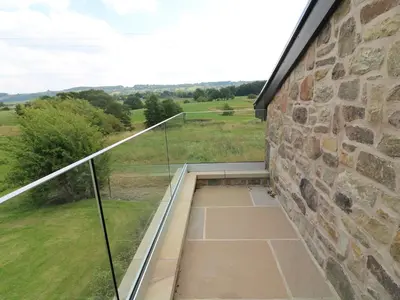 a balcony with a view of a stone wall at Deer Lodge in Blackburn