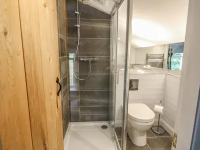 a bathroom with a toilet and a glass shower at Deer Lodge in Blackburn