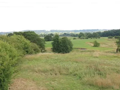a field of grass with trees in the distance at Deer Lodge in Blackburn
