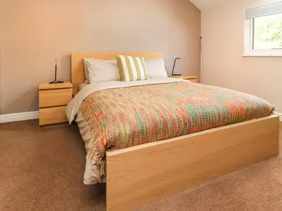 a bedroom with a large bed with a wooden headboard at Palm Court in Carnforth