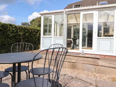 a table and chairs in front of a conservatory at Palm Court in Carnforth