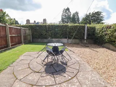 a bird cage in a yard with a fence at Palm Court in Carnforth