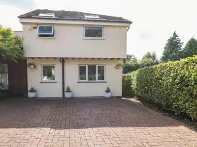 a white house with two windows and a brick driveway at Palm Court in Carnforth