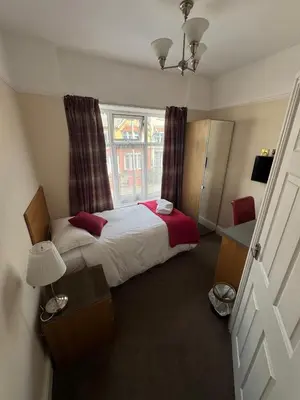 a small bedroom with a bed and a window at Rossdene House in Blackpool