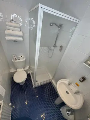 a bathroom with a shower and a toilet and a sink at Rossdene House in Blackpool