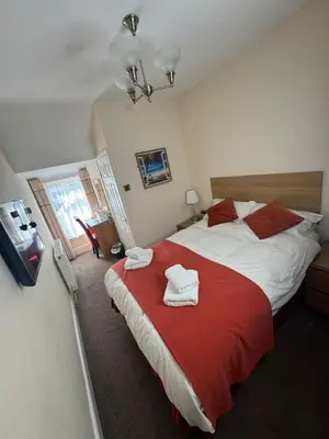 a bedroom with a large bed with towels on it at Rossdene House in Blackpool