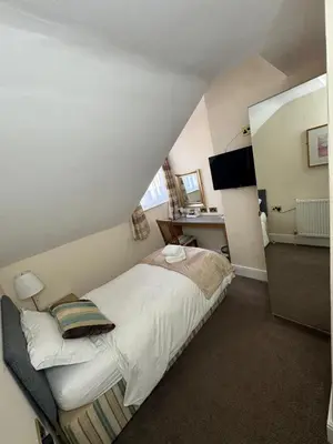 a bedroom with a bed and a desk in it at Rossdene House in Blackpool