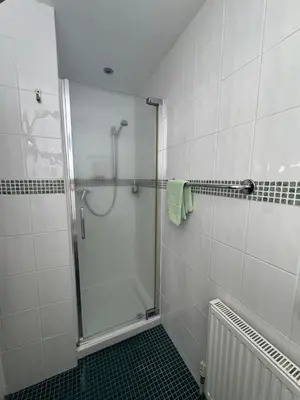 a shower with a glass door in a bathroom at Rossdene House in Blackpool