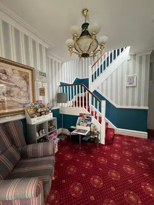 a living room with a staircase and a couch at Rossdene House in Blackpool