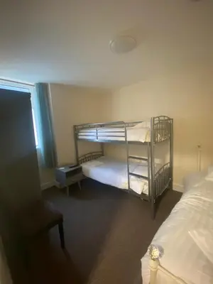 a bedroom with two bunk beds and a chair at The Hurstmere in Blackpool