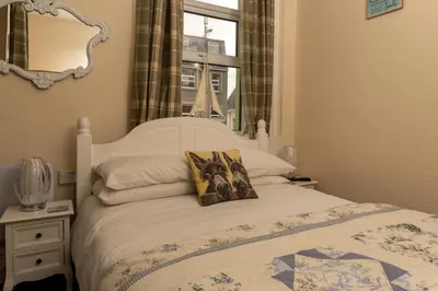 a bedroom with a white bed with a mirror at The Hurstmere in Blackpool