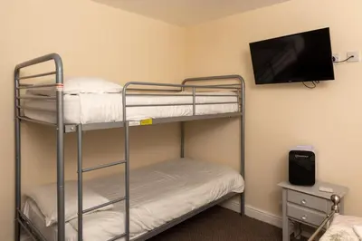 a room with two bunk beds and a flat screen tv at The Hurstmere in Blackpool