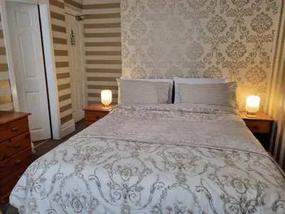 a bedroom with a white bed with two lamps on tables at Sirocco Blues Guest House in Blackpool