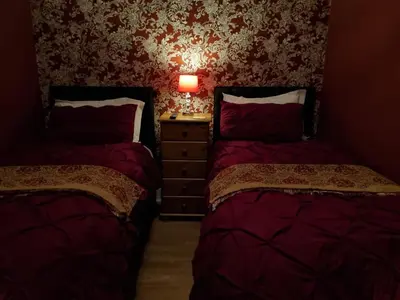 a bedroom with two beds and a dresser with a lamp at Sirocco Blues Guest House in Blackpool