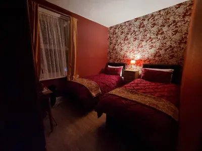 a small room with two beds and a window at Sirocco Blues Guest House in Blackpool