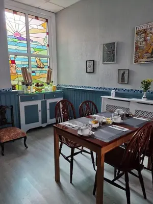 a dining room with a table and chairs and a window at Sirocco Blues Guest House in Blackpool