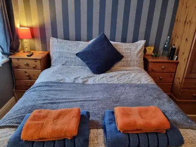 a bedroom with a bed with two towels on it at Sirocco Blues Guest House in Blackpool