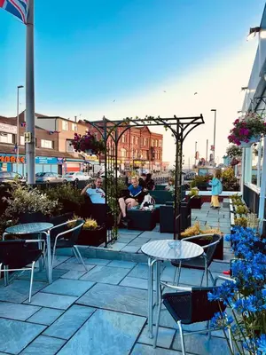 a patio with tables and chairs on a building at Danescourt Lodge in Blackpool