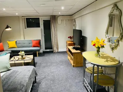 a living room with a couch a table and a tv at Danescourt Lodge in Blackpool