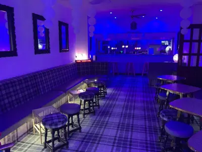 a purple room with tables and stools at Danescourt Lodge in Blackpool