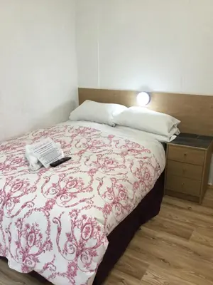 a bedroom with a bed with a red and white blanket at Danescourt Lodge in Blackpool