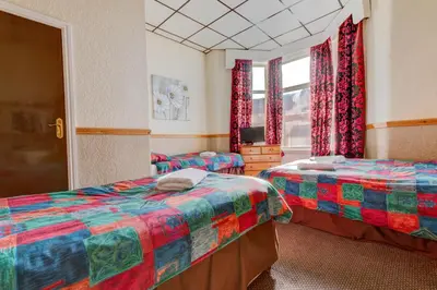 a room with two beds and a window at New Promenade Hotel in Blackpool