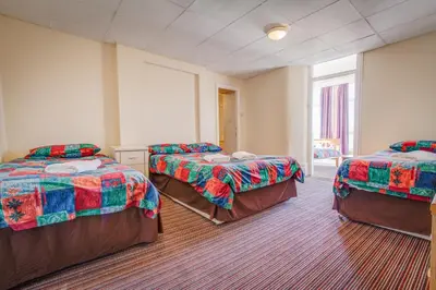 a room with three beds in a room at New Promenade Hotel in Blackpool