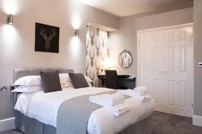 a bedroom with a large bed with towels on it at The Glebe Hotel in Liverpool