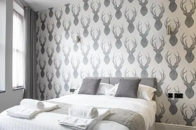 a bedroom with a bed with a black and white wallpaper at The Glebe Hotel in Liverpool