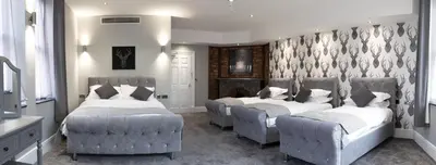 a bedroom with three beds and two chairs at The Glebe Hotel in Liverpool