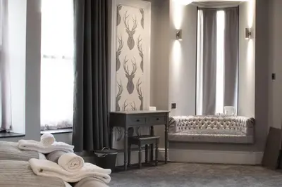 a bedroom with a bed and a table with towels at The Glebe Hotel in Liverpool
