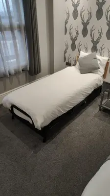 a bed in the corner of a room at The Glebe Hotel in Liverpool