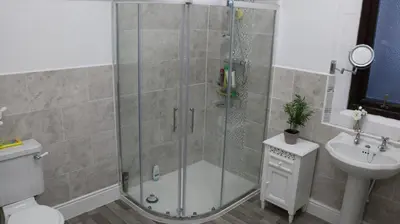 a bathroom with a shower and a toilet and a sink at Victoria House in Barrow in Furness