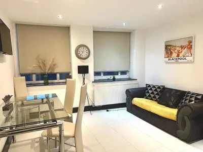 a living room with a couch and a table and a clock at Winter Gardens Service Apartments 2 by Blackpool Service Apartments in Blackpool